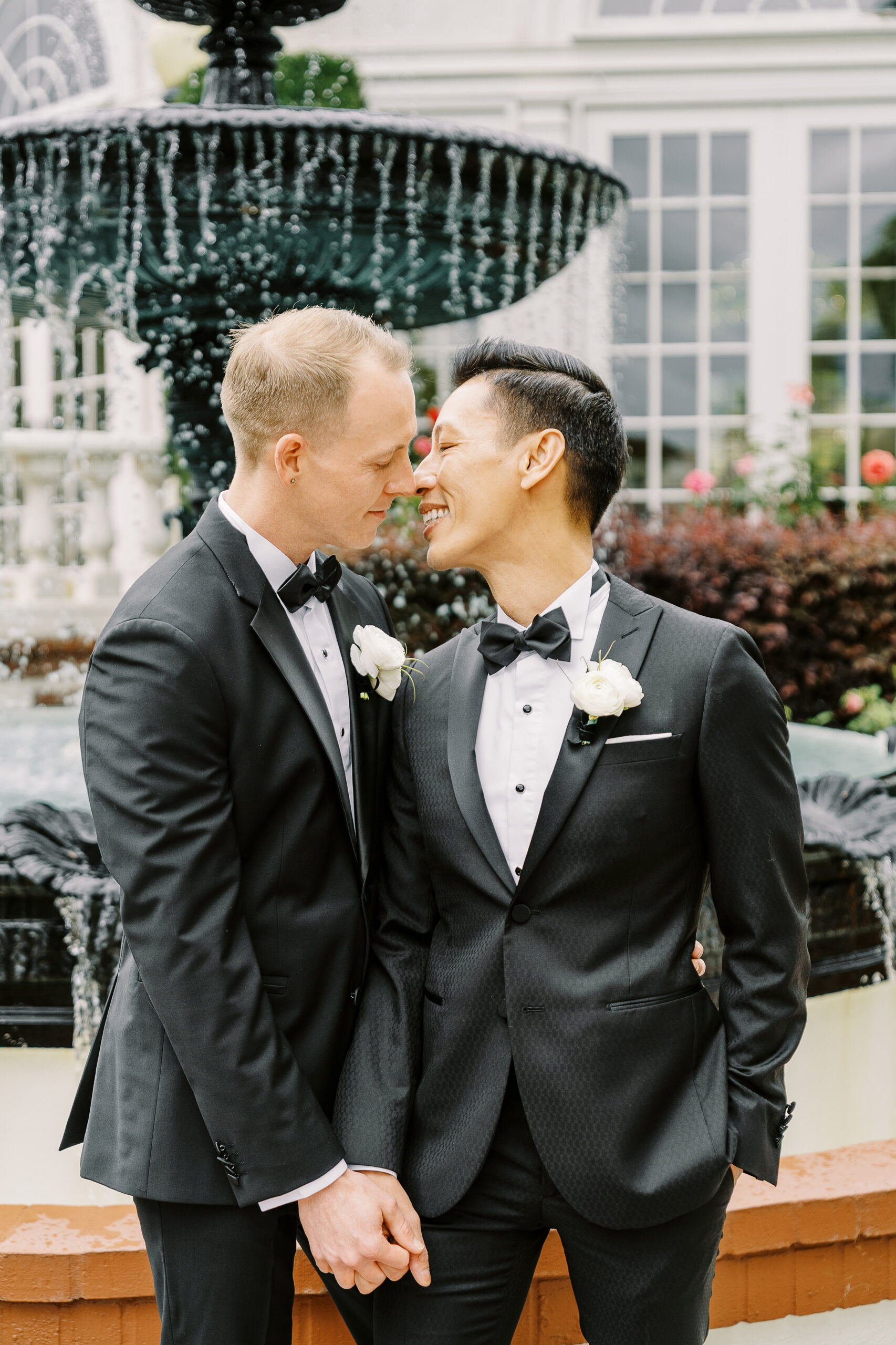two grooms share a kiss in front of the water fountain at their vizcaya sacramento wedding