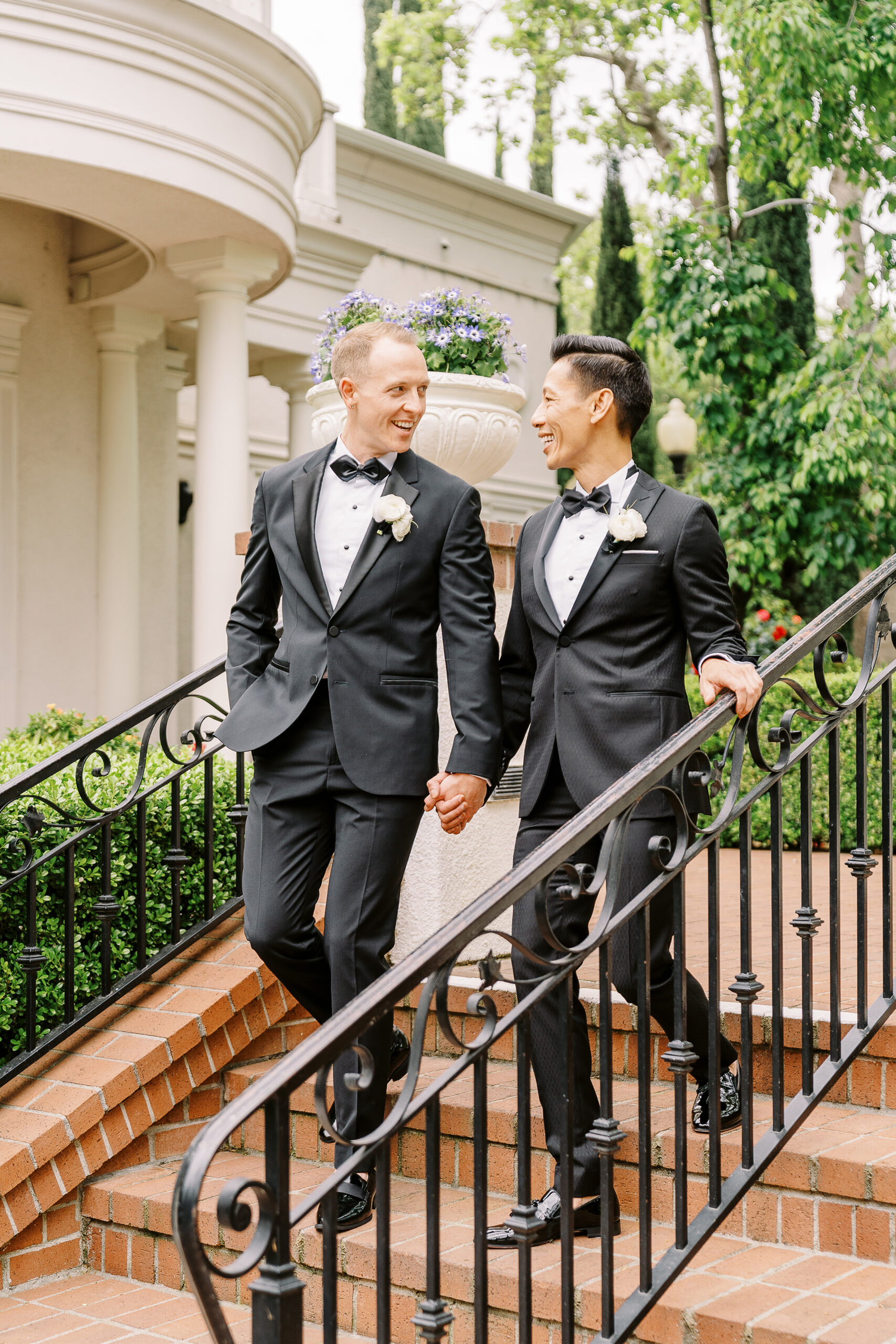 two grooms chat together while walking down the steps at their vizcaya sacramento wedding