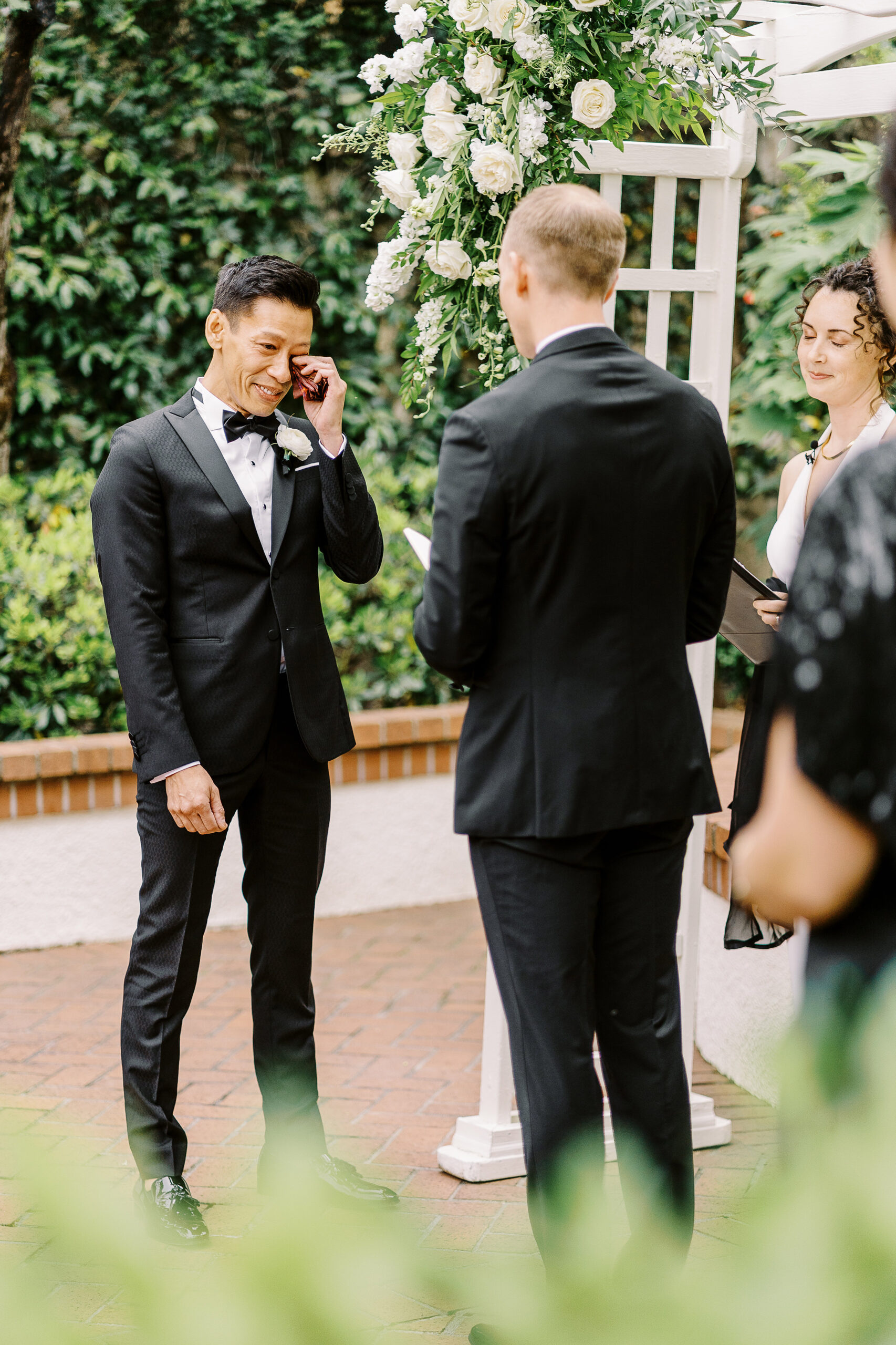 a groom wipes away a tear at a lgbtq vizcaya sacramento wedding ceremony