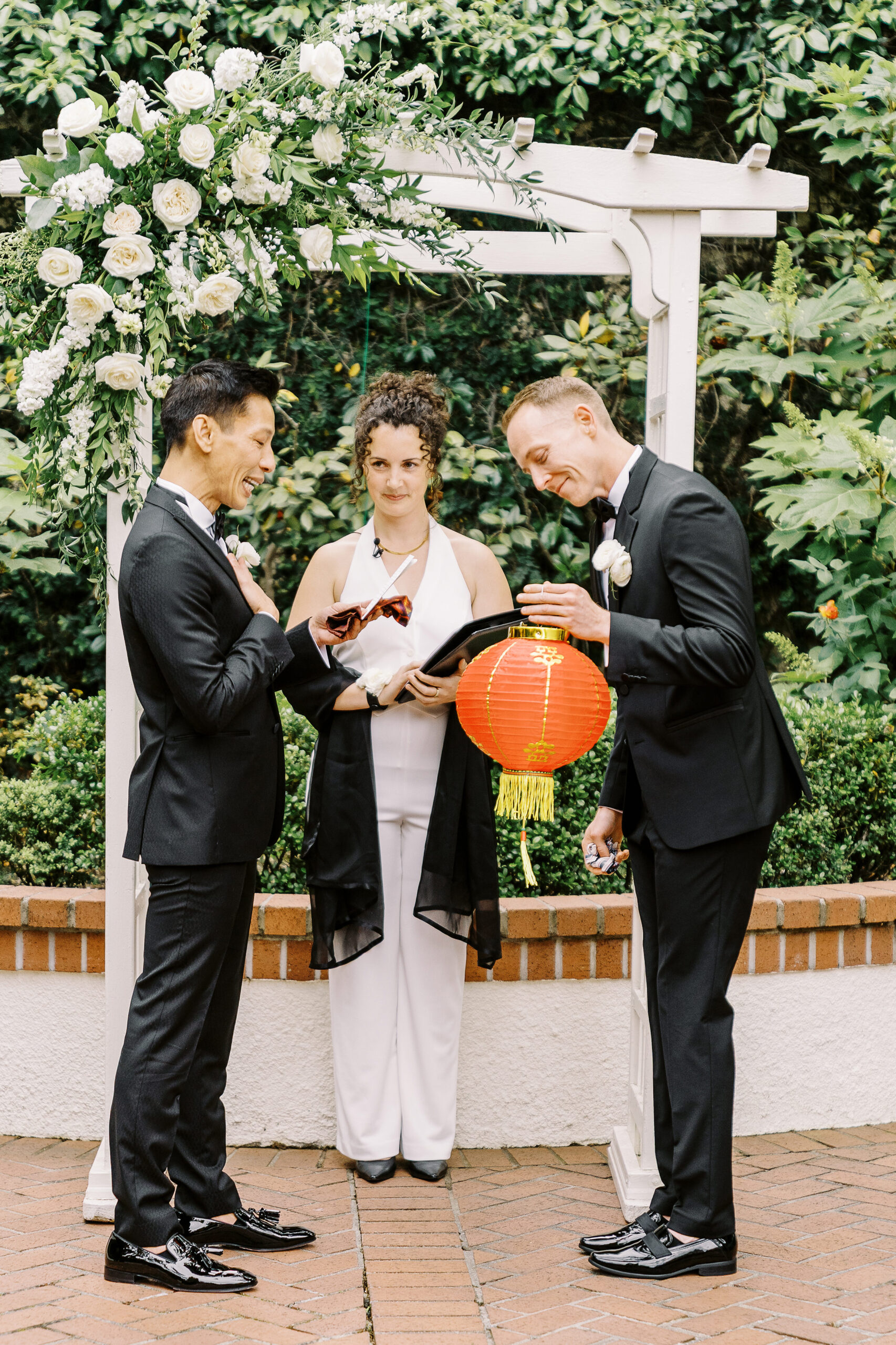 a groom reads his vows while his fiance holds a red lantern at their vizcaya sacramento wedding