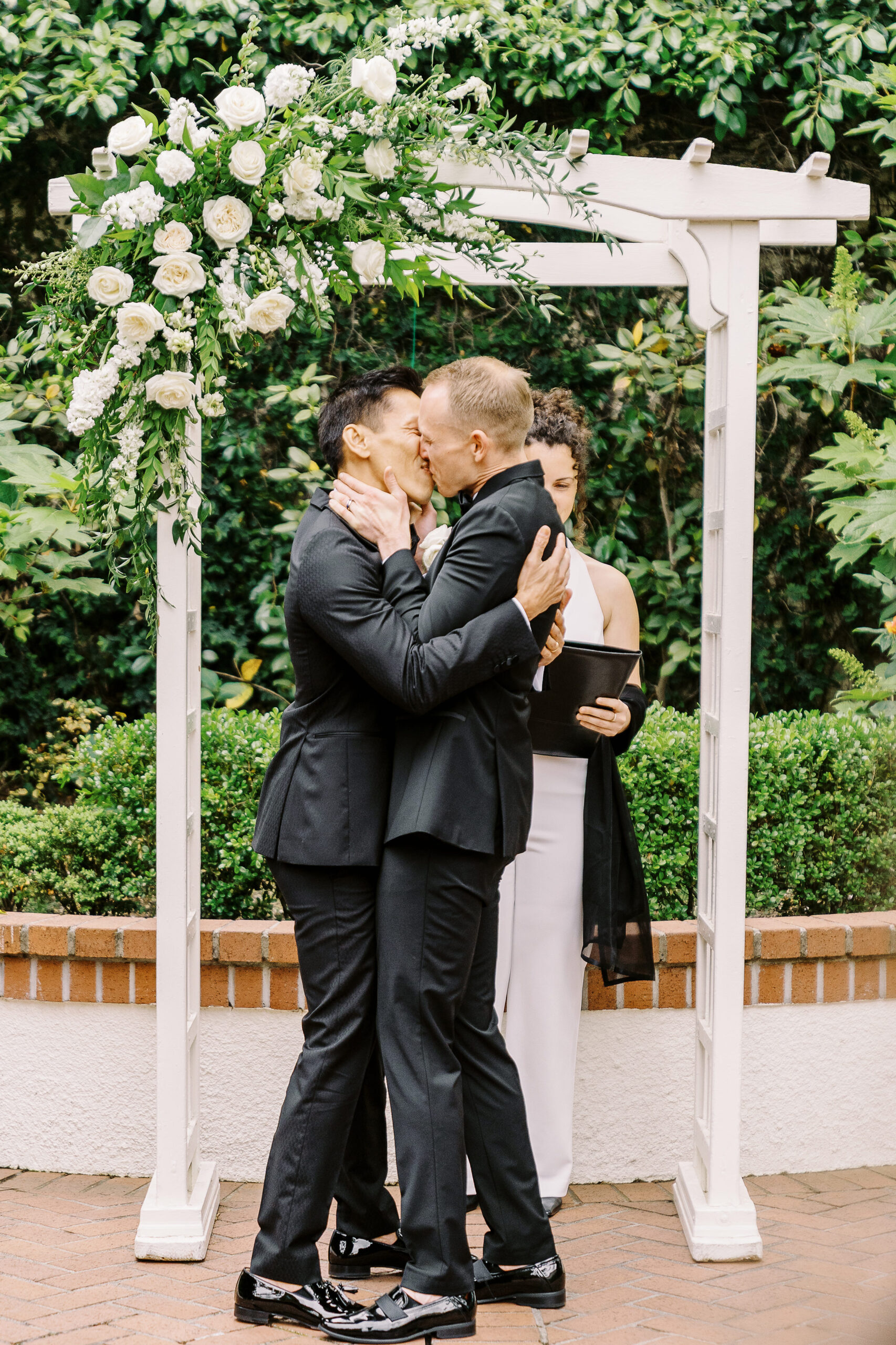 two grooms share their first kiss as husbands at their vizcaya sacramento wedding ceremony