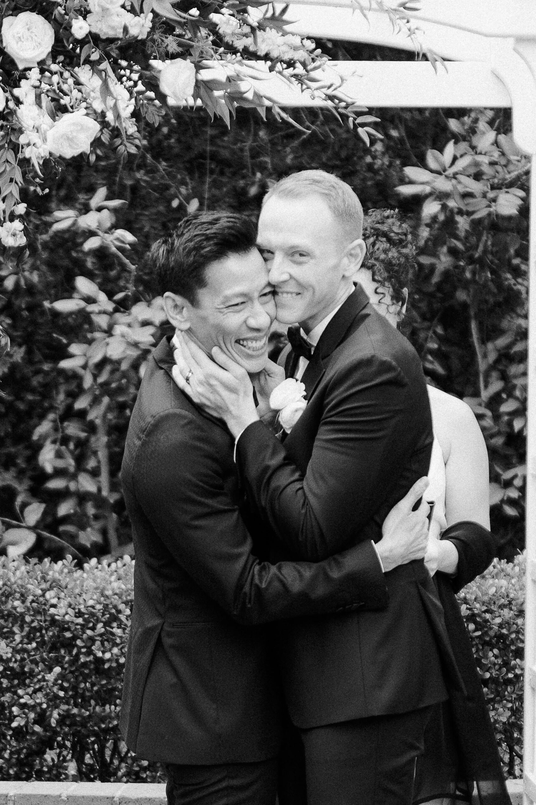 a black and white photos of two grooms immediately following their first kiss as husbands at their vizcaya sacramento wedding ceremony
