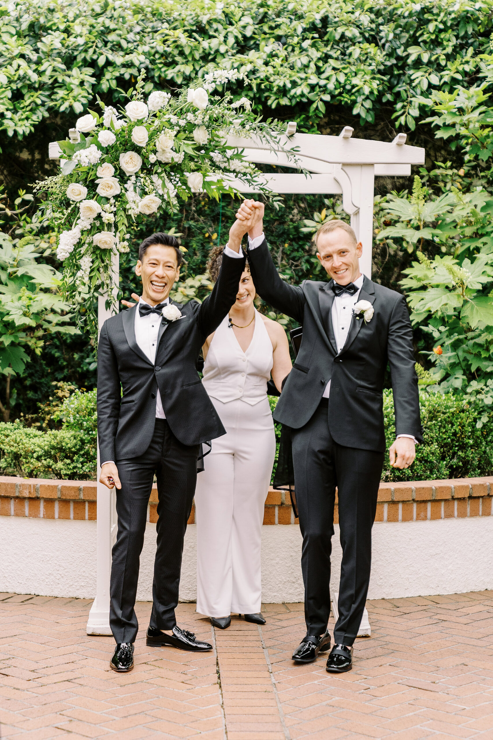 two grooms celebrate immediately following their first kiss as husbands at their vizcaya sacramento wedding ceremony