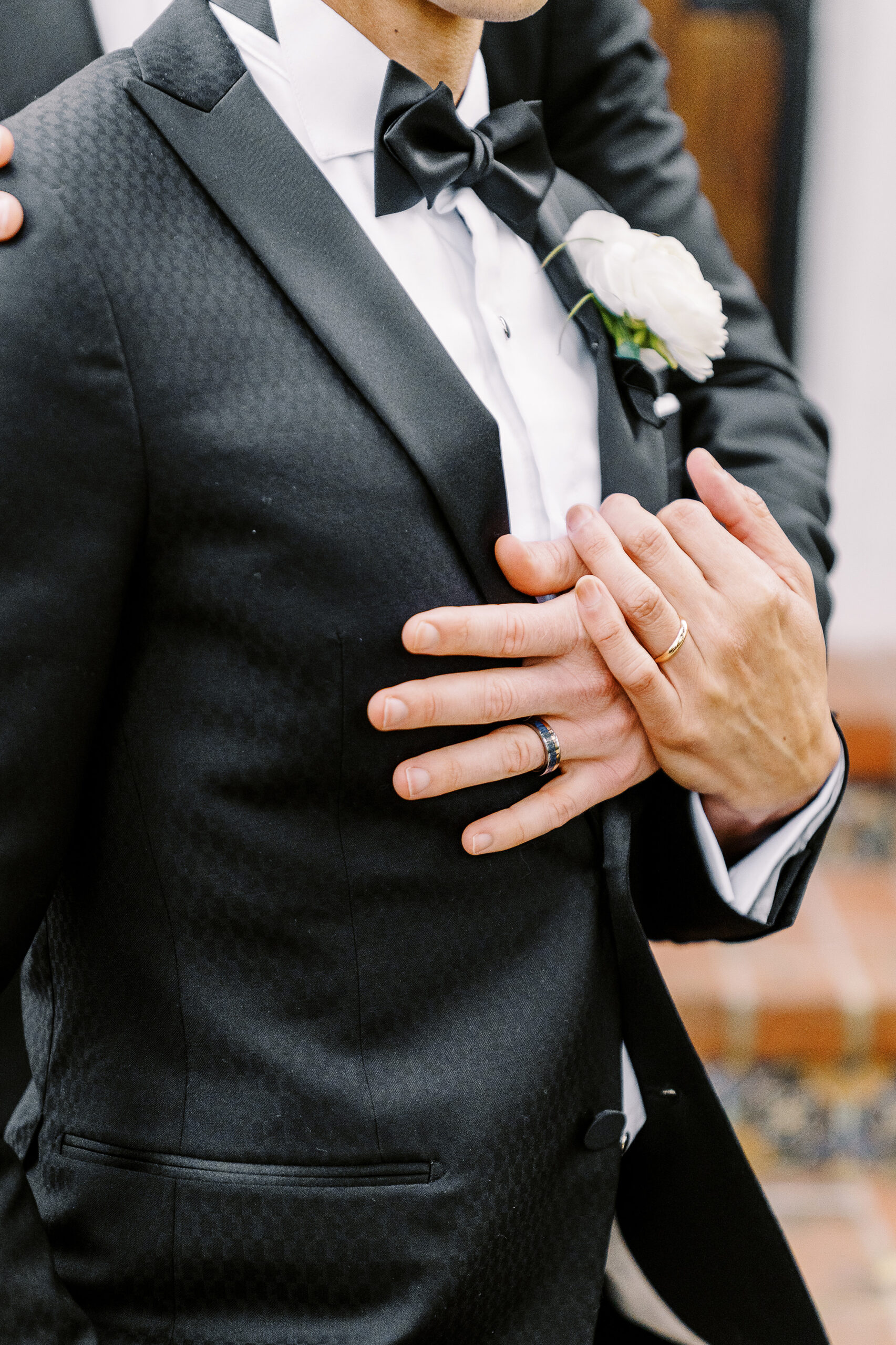 a close up photo of groom's hands showing off their wedding rings at their vizcaya sacramento wedding