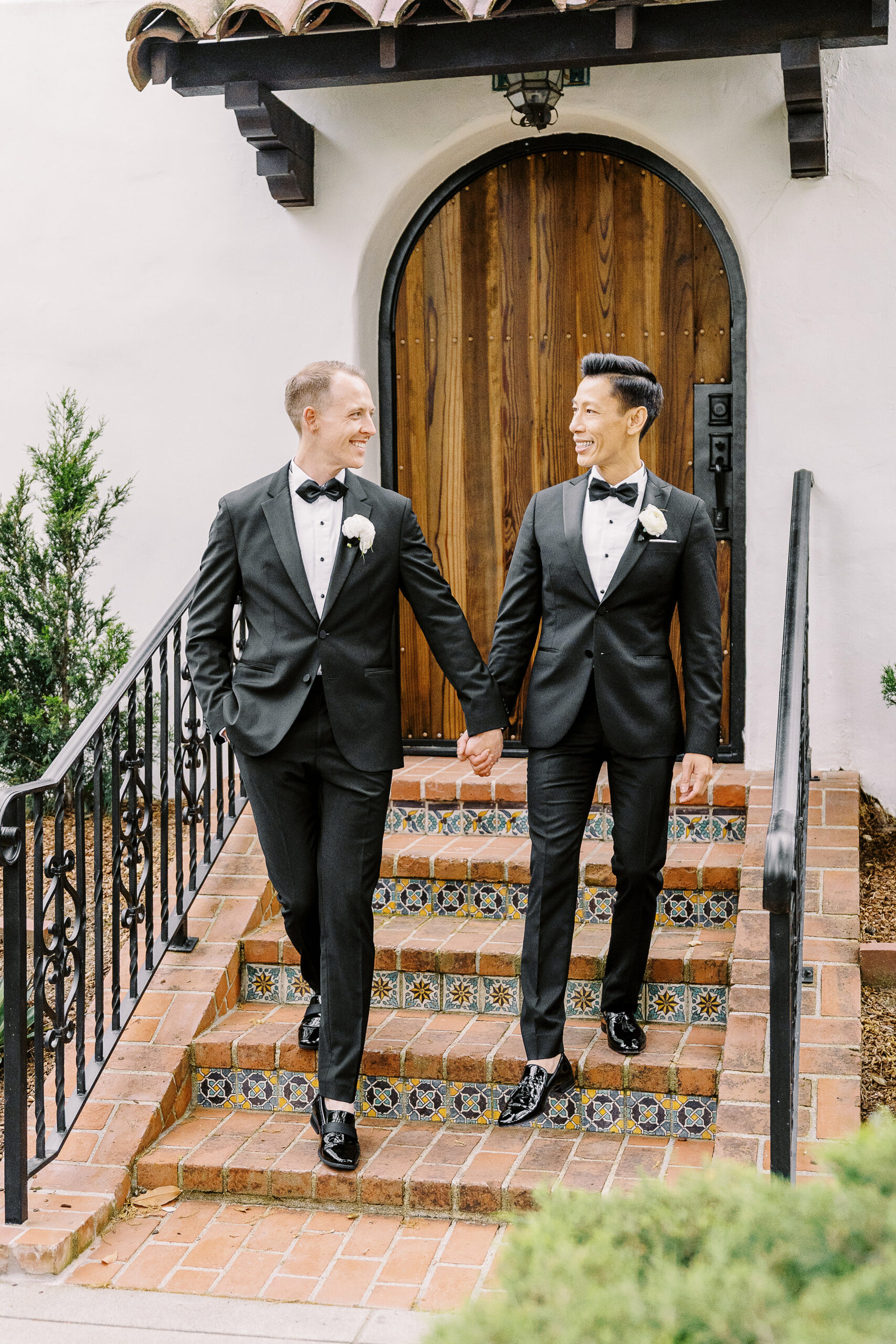 two grooms walk down some steps holding hands at their vizcaya sacramento wedding