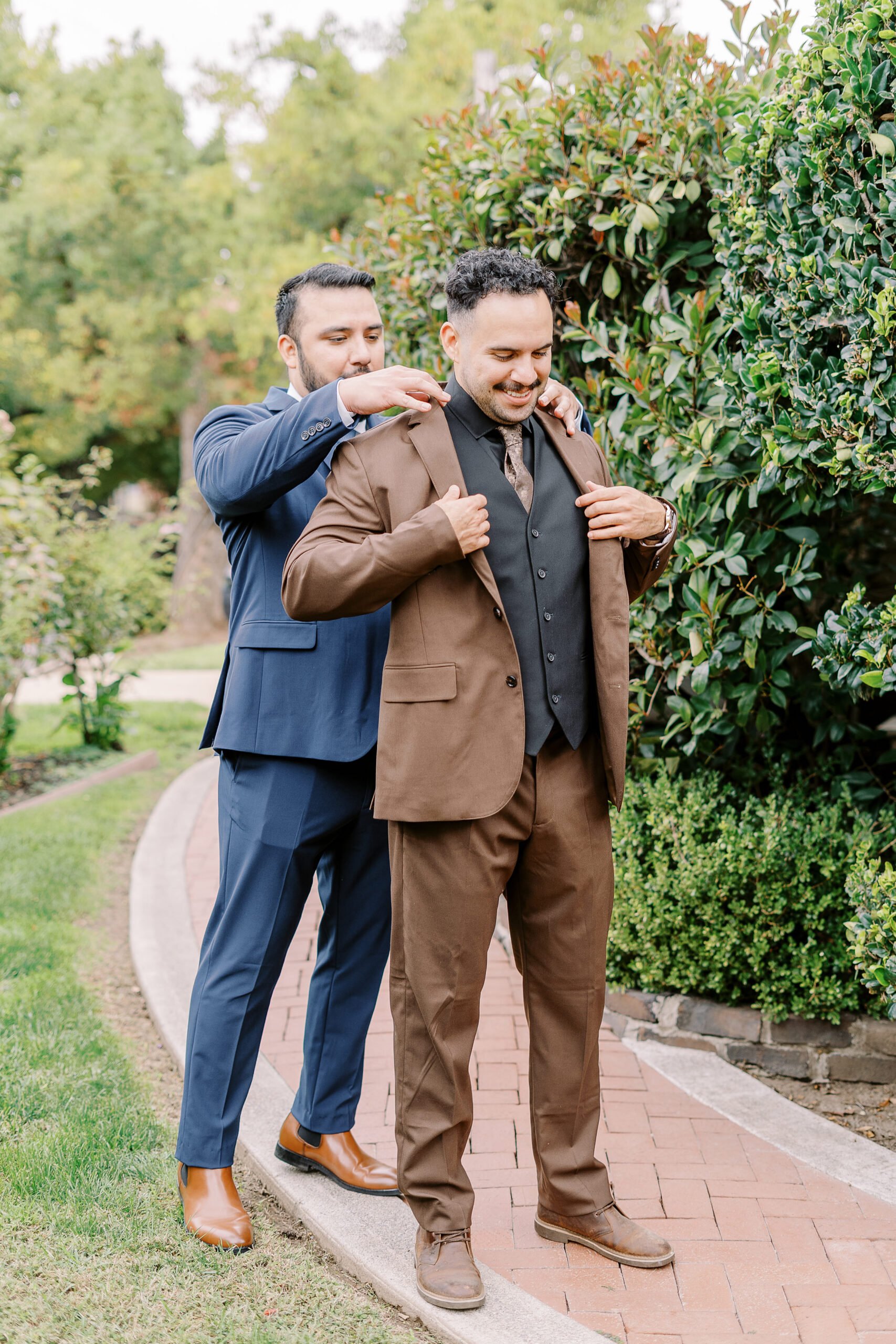 a groom is helped into his suit jacket at Vizcaya photographed by Sacramento wedding photographers