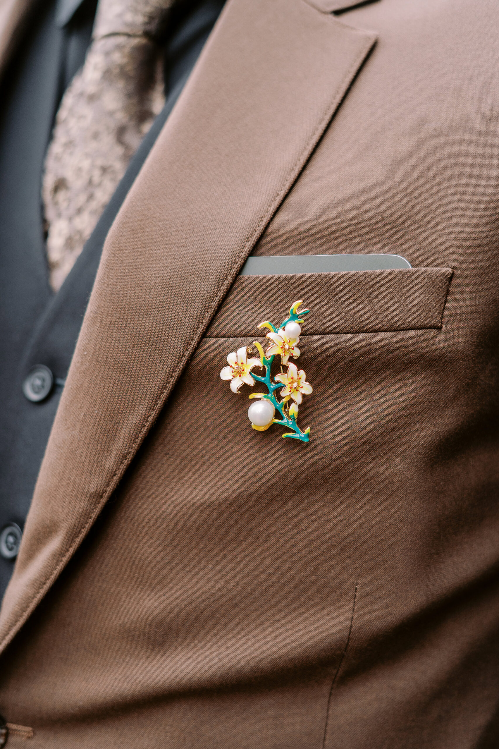 a close up of an enamel pin boutonniere at Vizcaya photographed by Sacramento wedding photographers