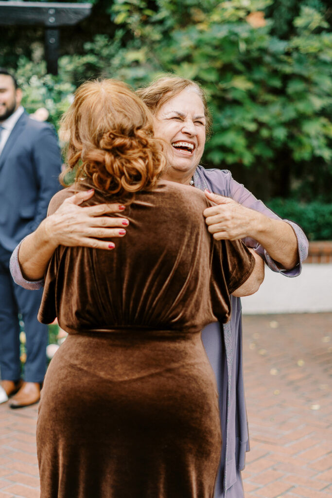 a grandmother laughs while hugging the brides mother at Vizcaya photographed by Sacramento wedding photographers
