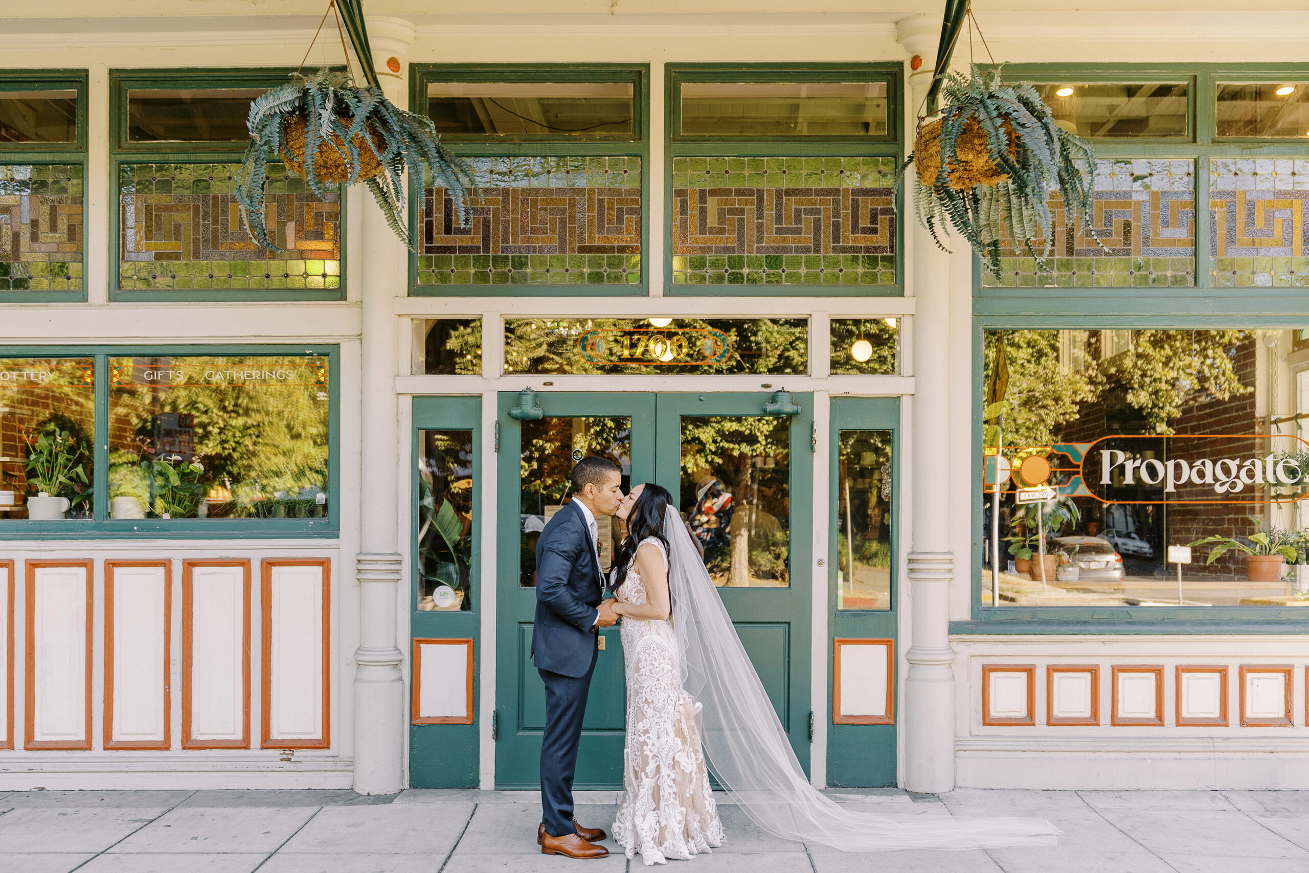 a bride and groom hold hands and share a kiss at their midtown Sacramento wedding photographed by Sacramento wedding photographer