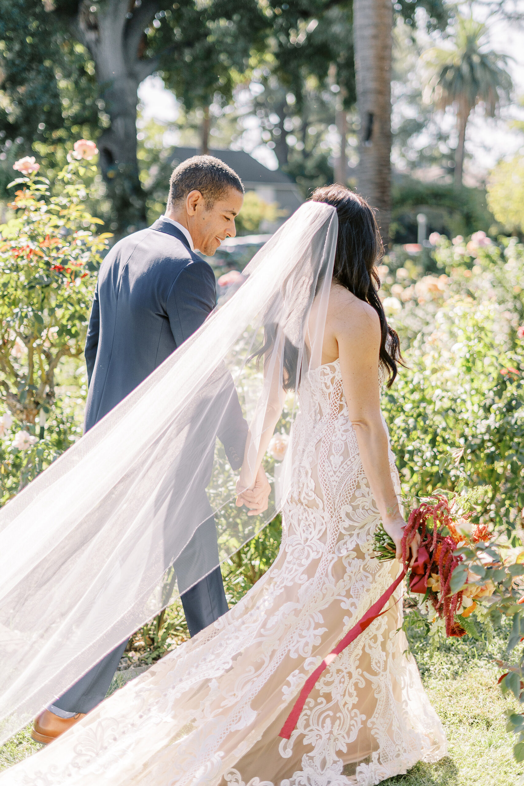 a bride and groom walk through the McKinley Park Rose Garden at their midtown Sacramento wedding photographed by Sacramento wedding photographer