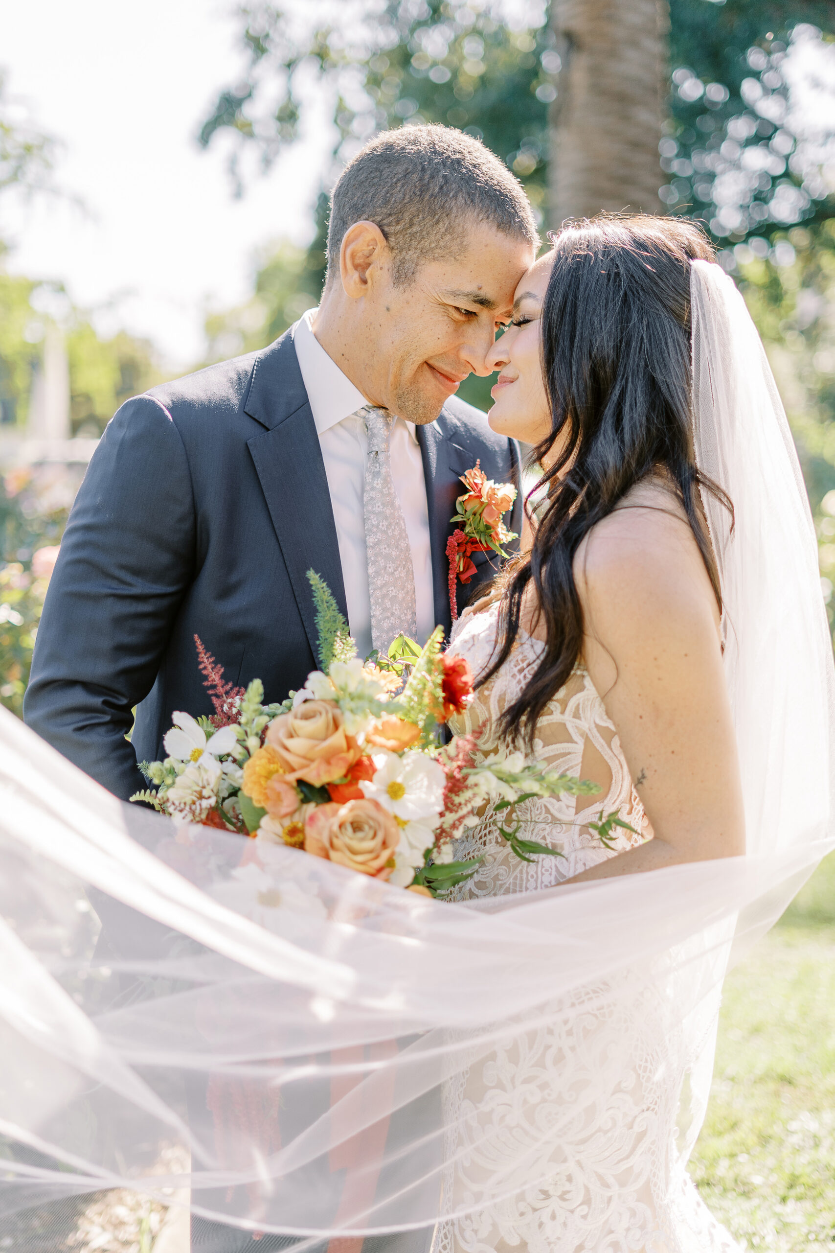 a bride and groom rest their foreheads together in the McKinley Park Rose Garden at their midtown Sacramento wedding photographed by Sacramento wedding photographer