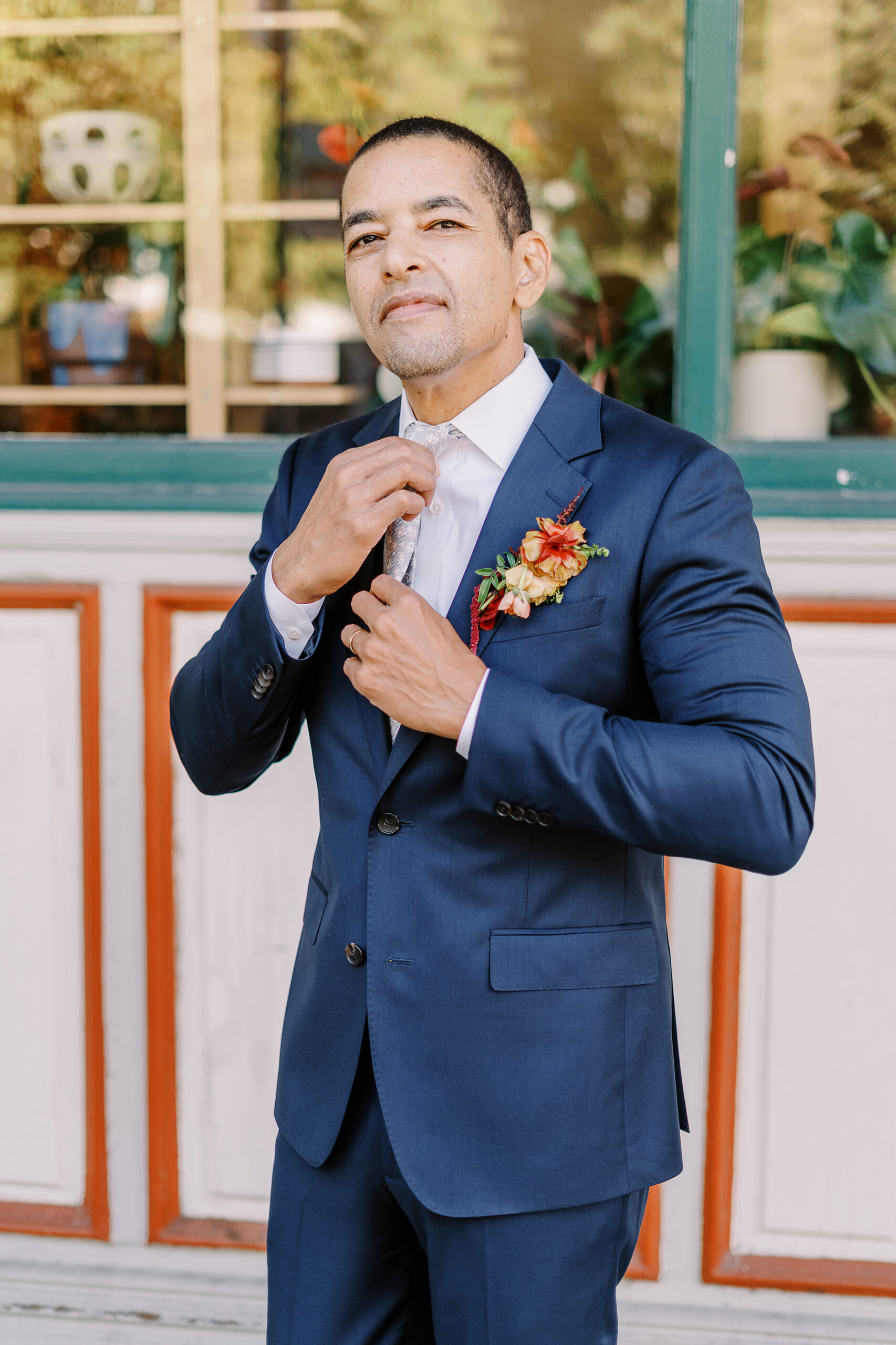 a groom adjusts his tie at his midtown Sacramento wedding photographed by Sacramento wedding photographer
