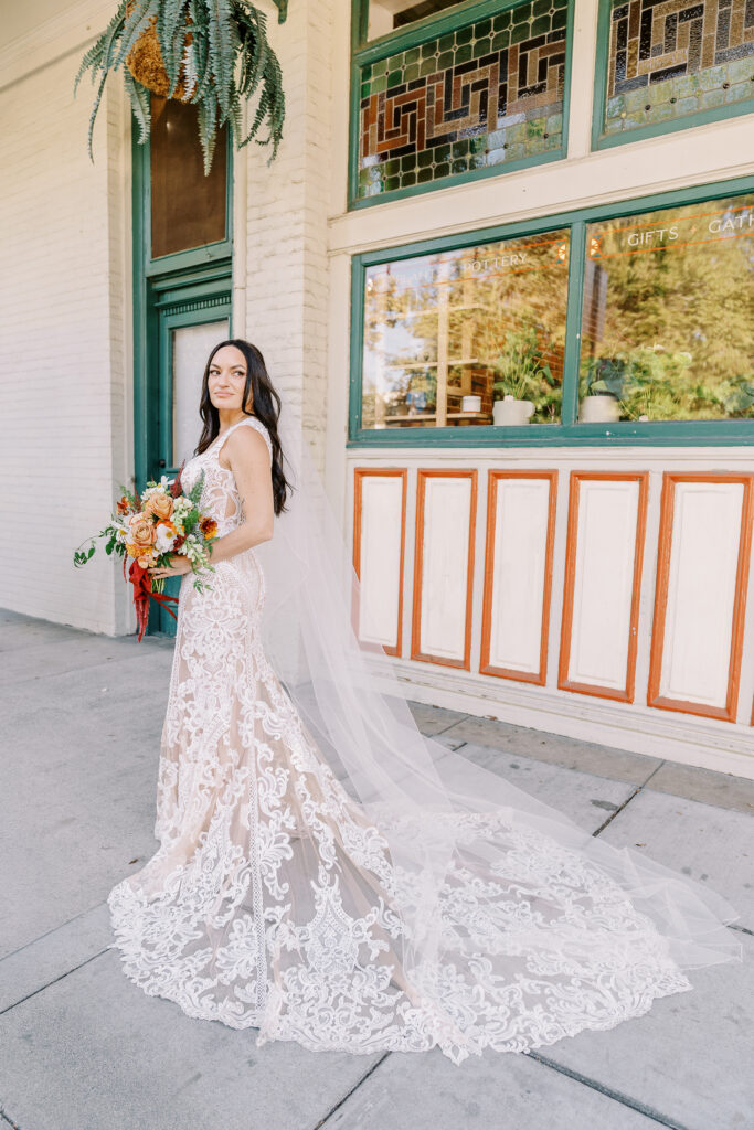 a bride holds her bouquet of orange and white flowers at her midtown Sacramento wedding photographed by Sacramento wedding photographer