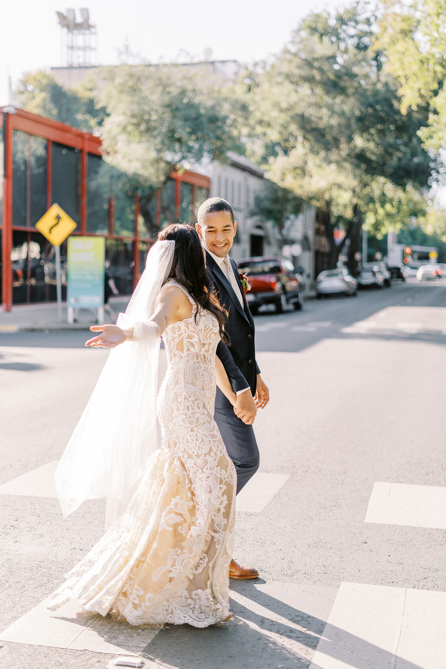 a bride and groom walk down the street at their midtown Sacramento wedding photographed by Sacramento wedding photographer