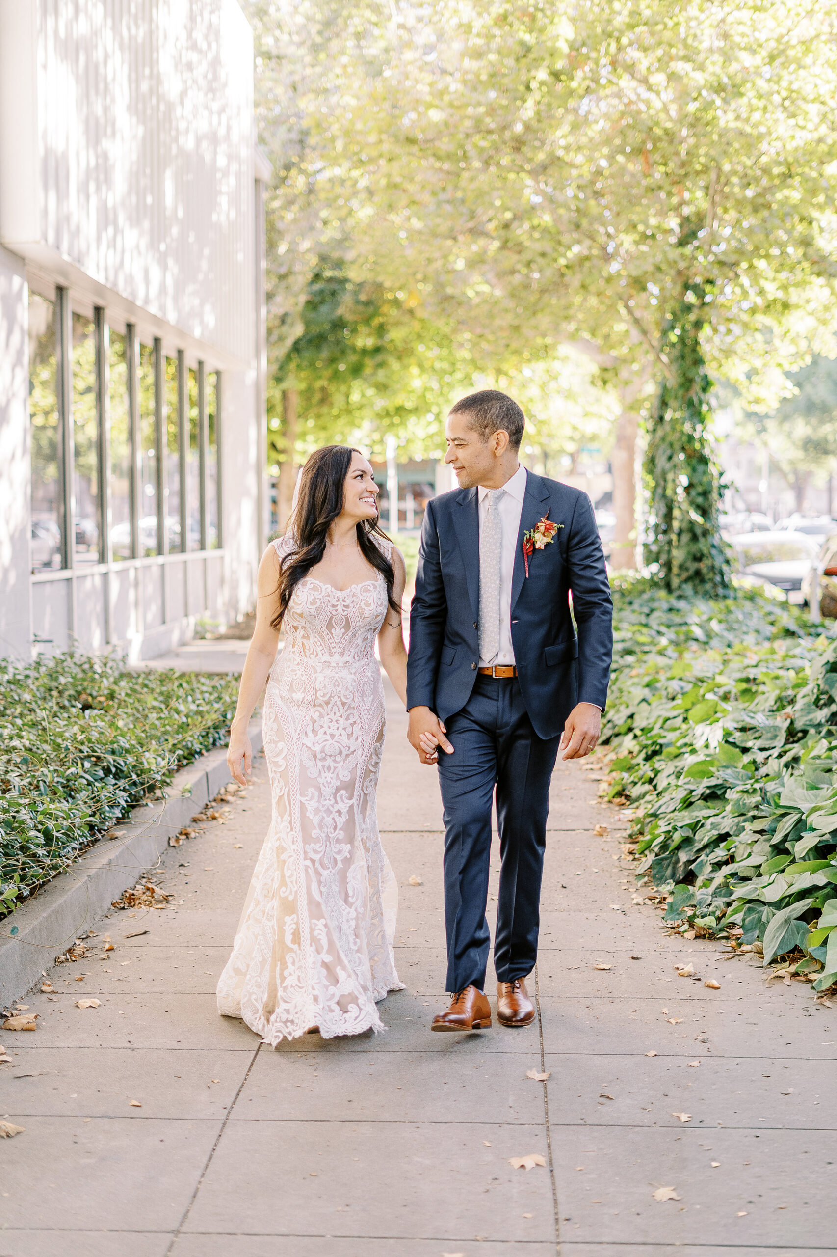 a bride and groom walk down the street at their midtown Sacramento wedding photographed by Sacramento wedding photographer