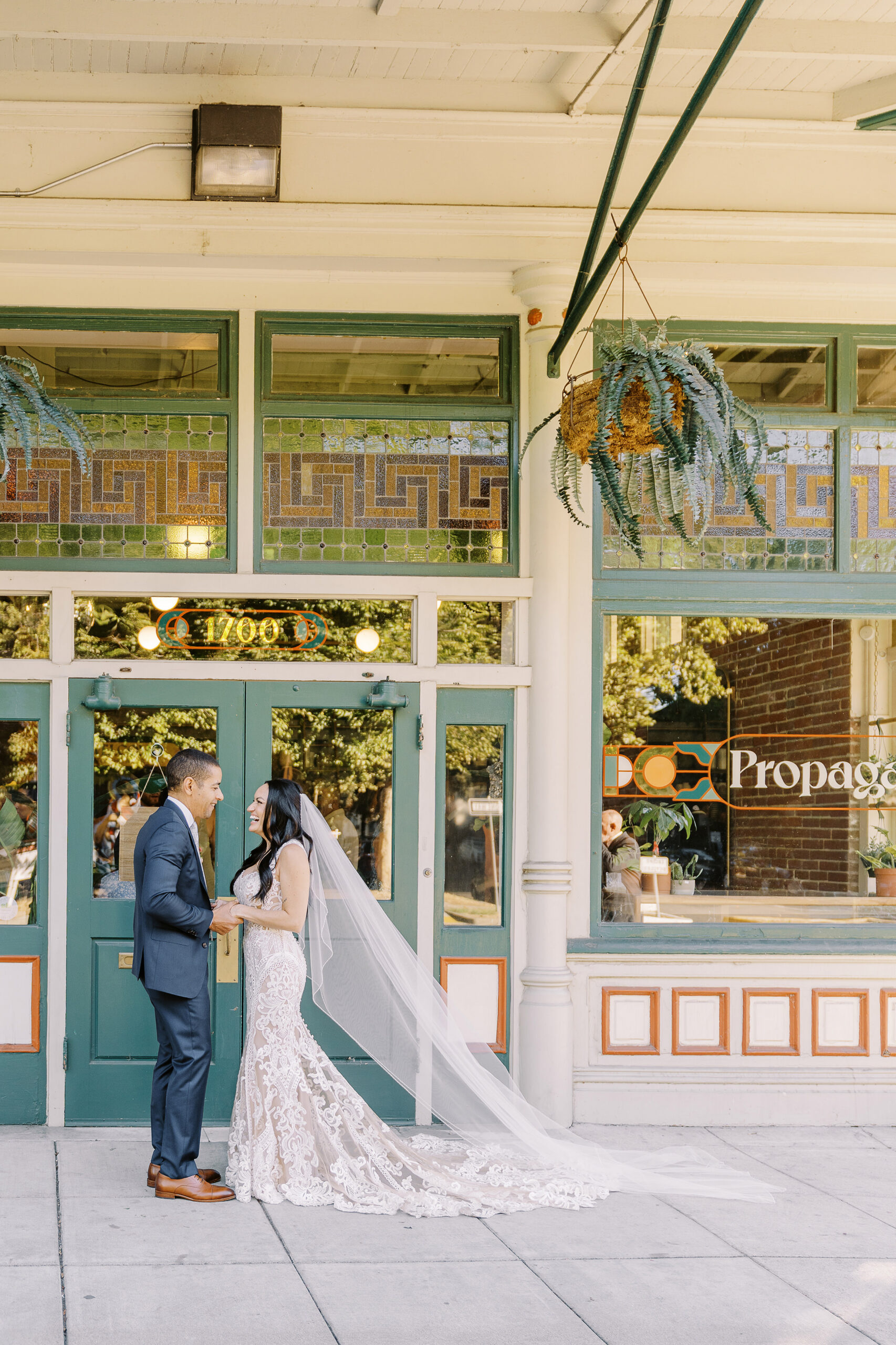 a bride and groom hold hands and laugh together at their midtown Sacramento wedding photographed by Sacramento wedding photographer