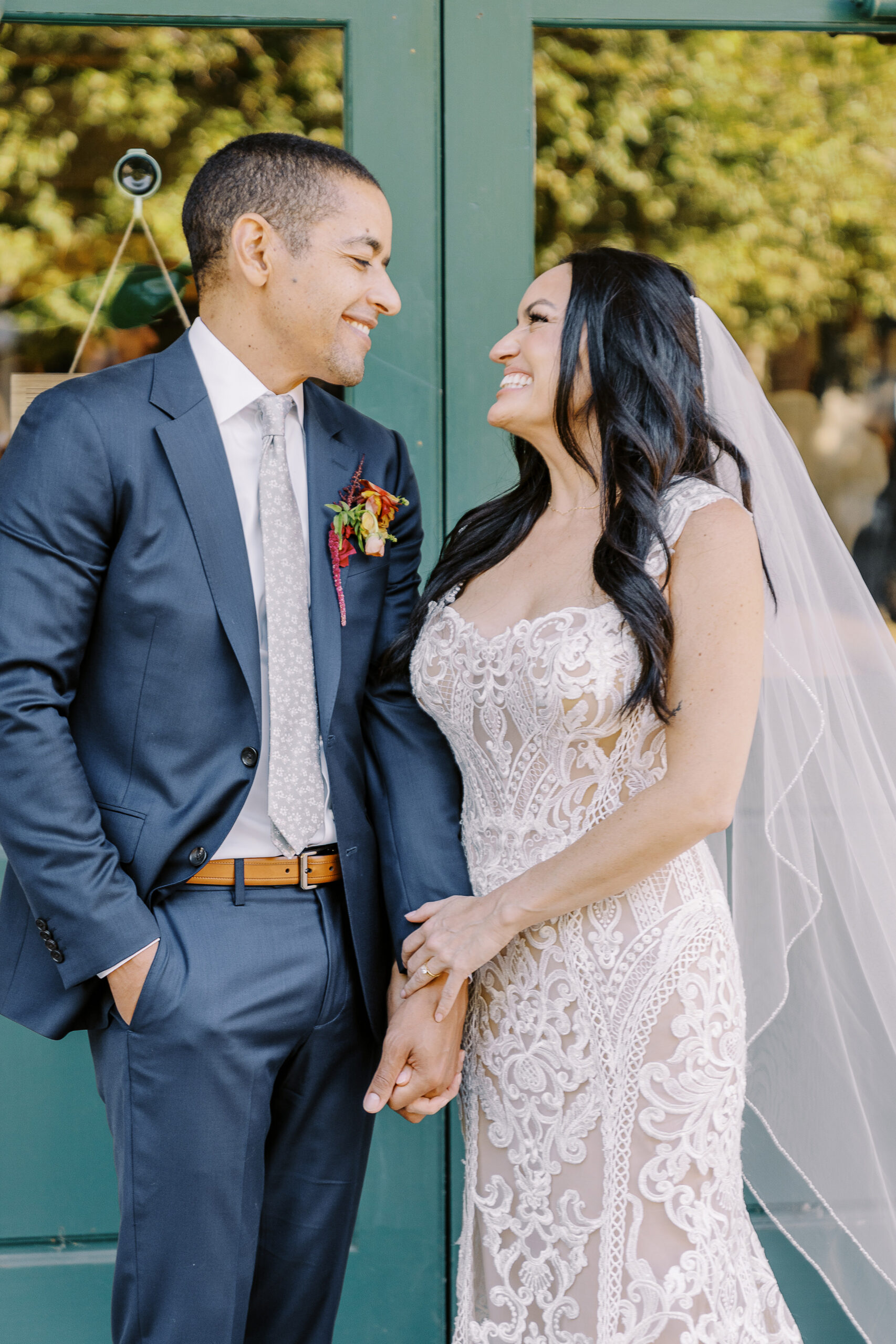 a bride and groom hold hands and laugh together at their midtown Sacramento wedding photographed by Sacramento wedding photographer