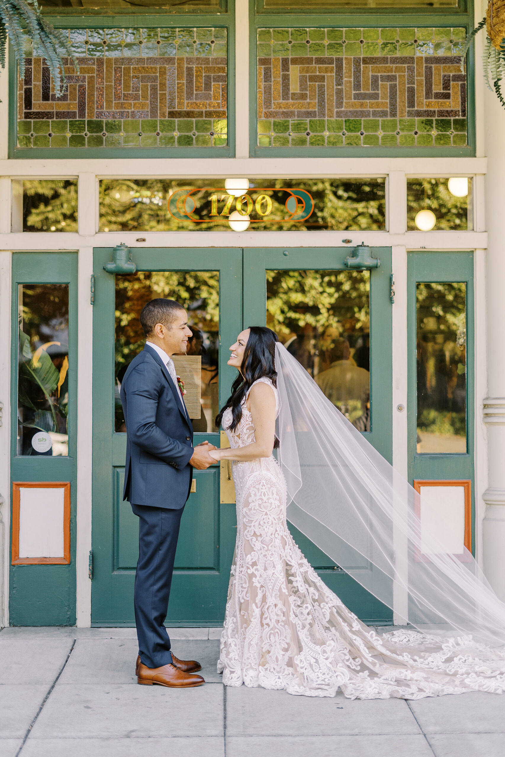 a bride and groom hold hands and laugh together at their midtown Sacramento wedding photographed by Sacramento wedding photographer