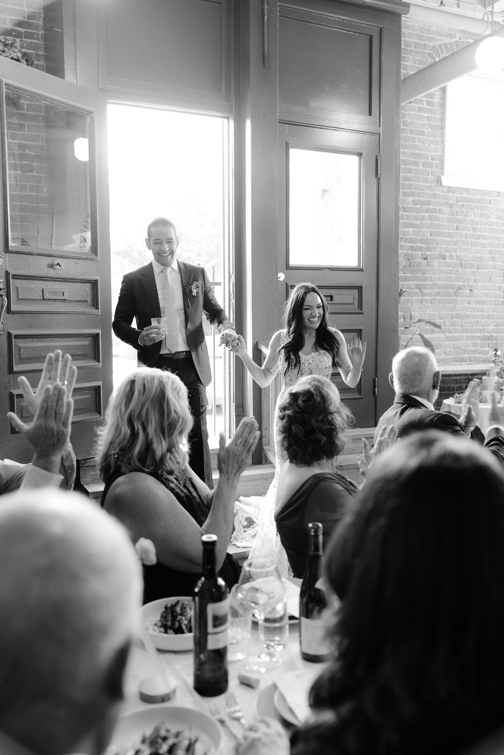 a bride and groom enter their wedding reception at their midtown Sacramento wedding photographed by Sacramento wedding photographer