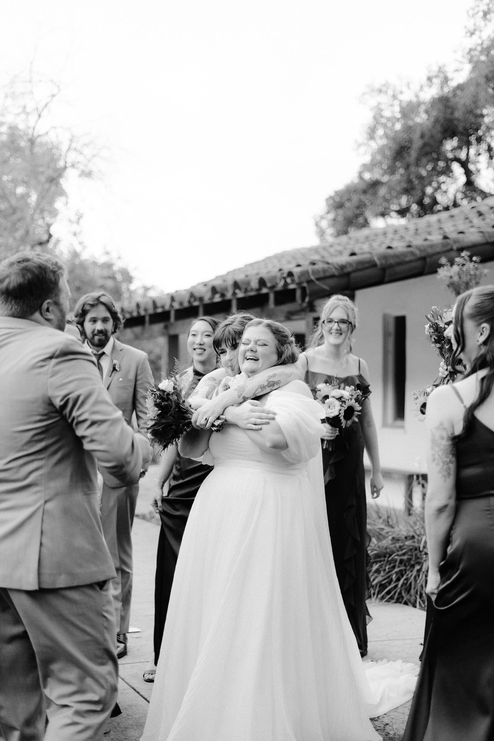 a bride laughs while crying and being hugged by her maid of honor at The Maples Woodland photographed by Sacramento wedding photographer