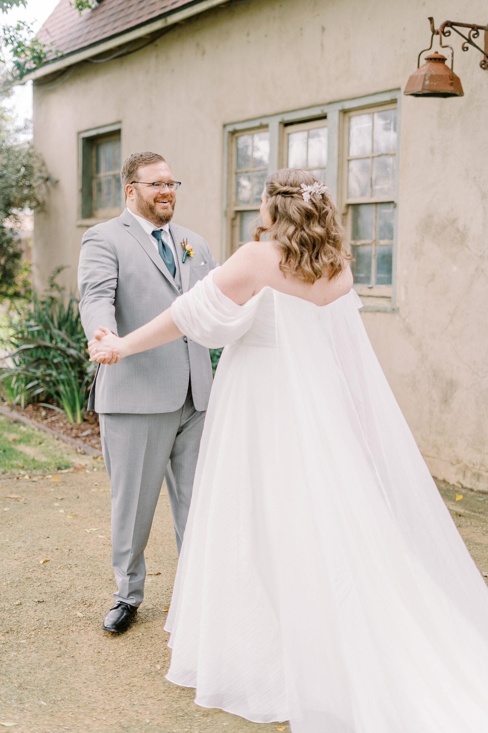 a bride and groom share their first look in front of the stables at The Maples Woodland photographed by Sacramento wedding photographer