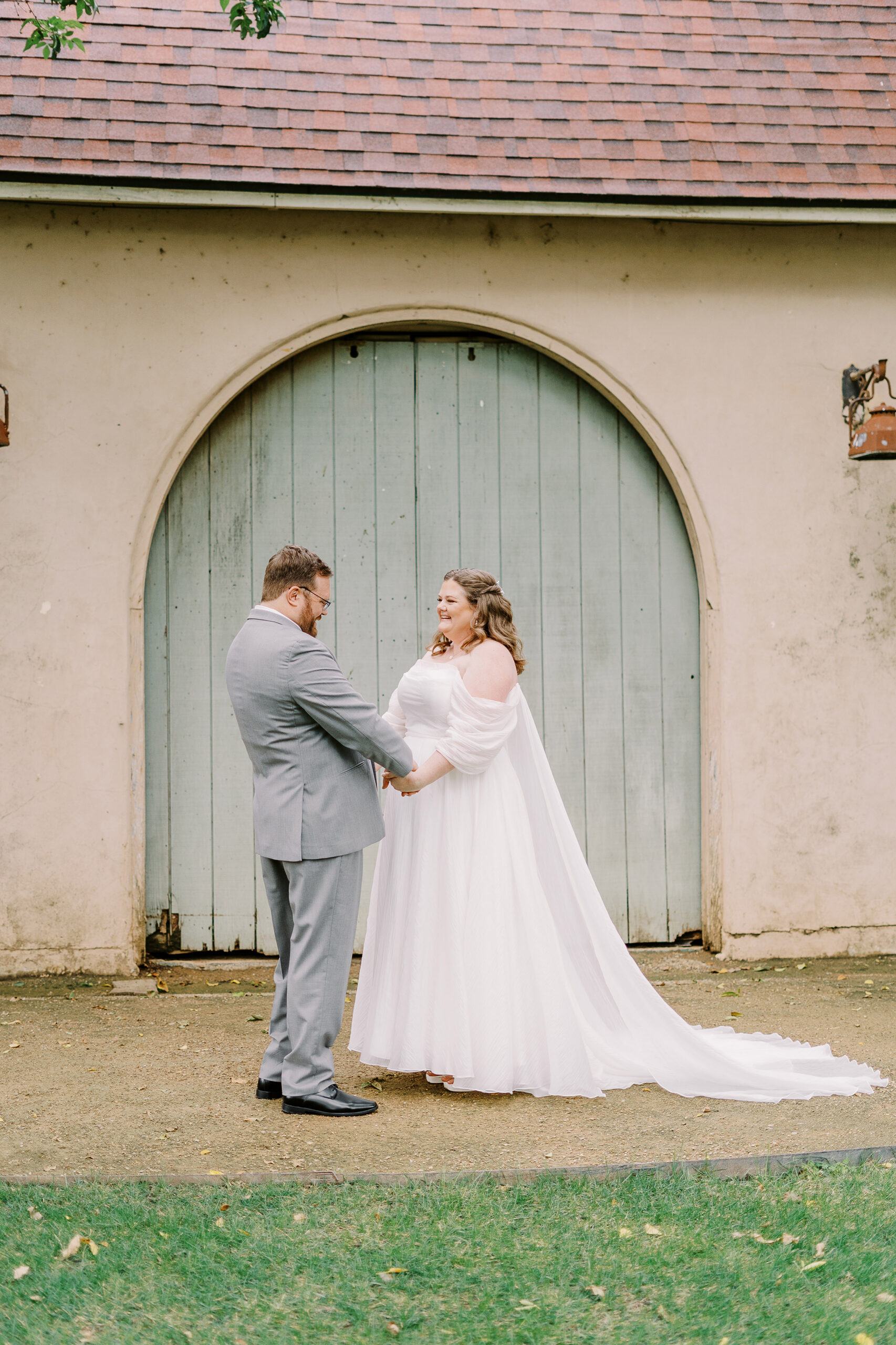 a bride and groom share their first look in front of the stables at The Maples Woodland photographed by Sacramento wedding photographer