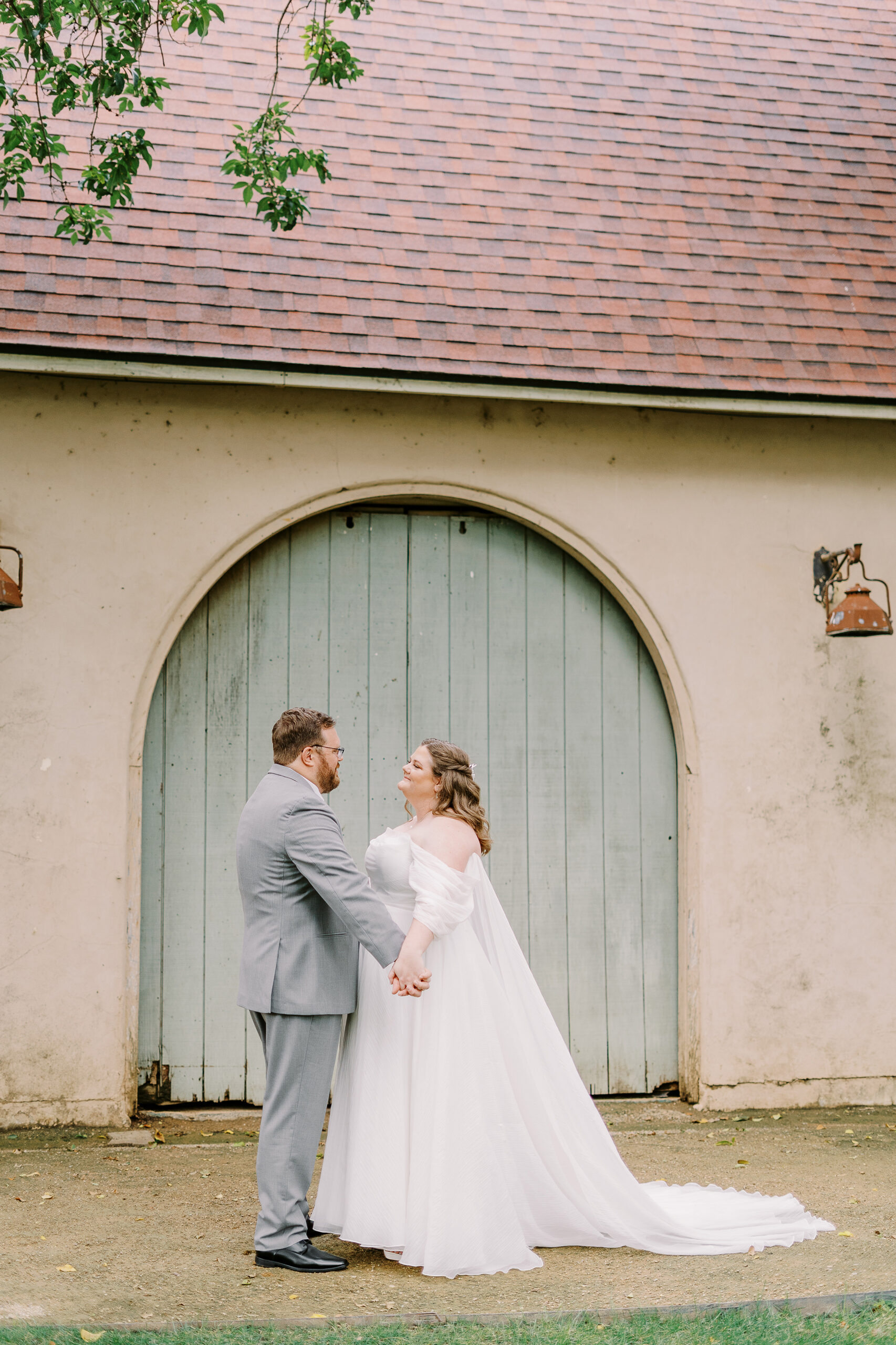 a bride and groom share their first look in front of the stables at The Maples Woodland photographed by Sacramento wedding photographer