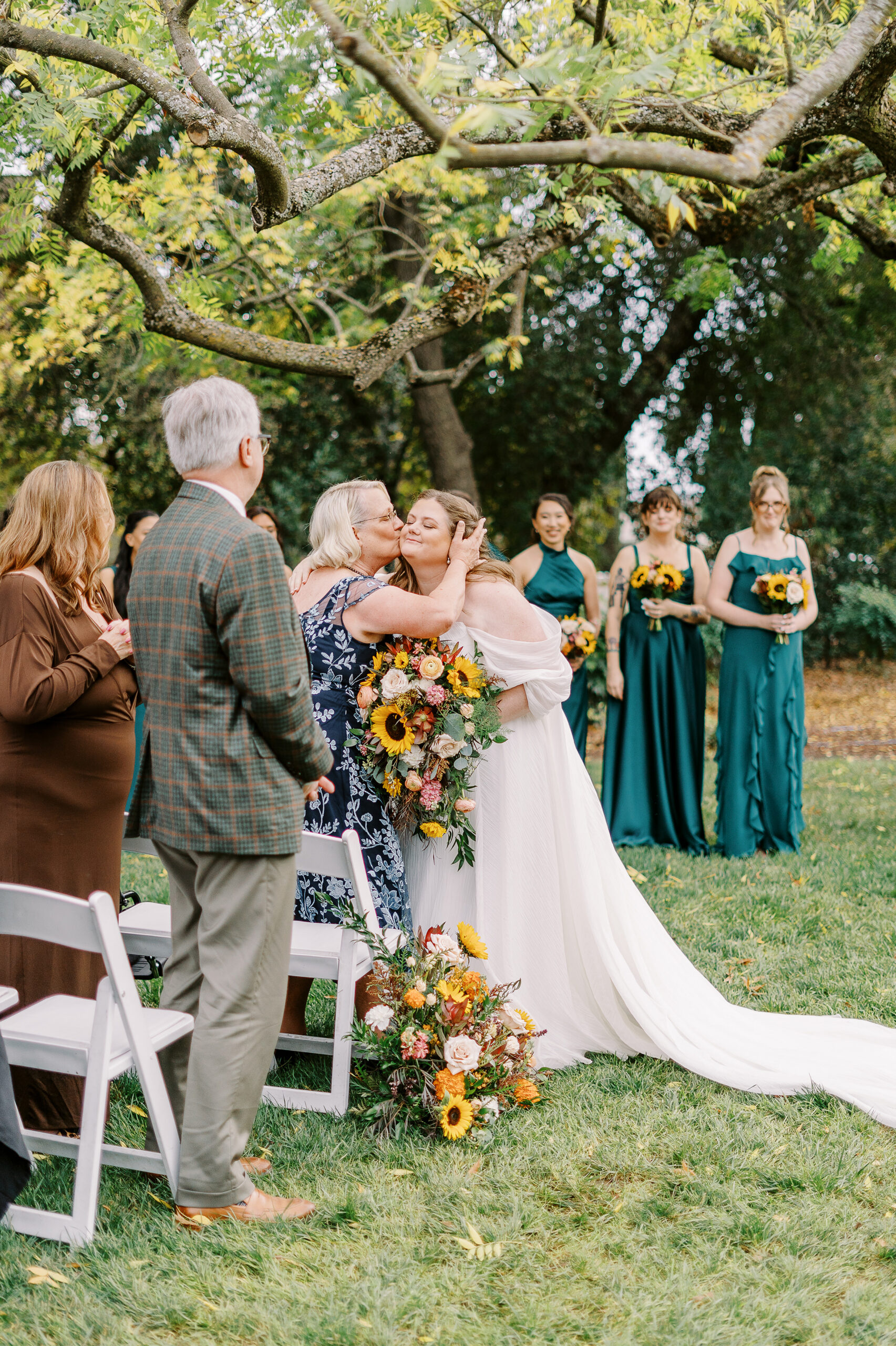 a brides mom kisses her cheek at a ceremony at The Maples Woodland photographed by Sacramento wedding photographer