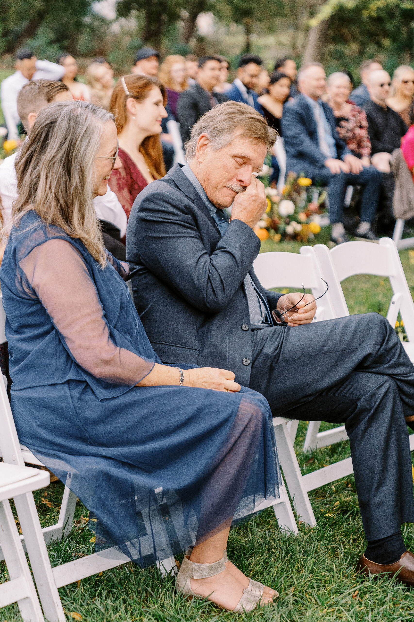 the father of the groom wipes away a tear at a ceremony at The Maples Woodland photographed by Sacramento wedding photographer