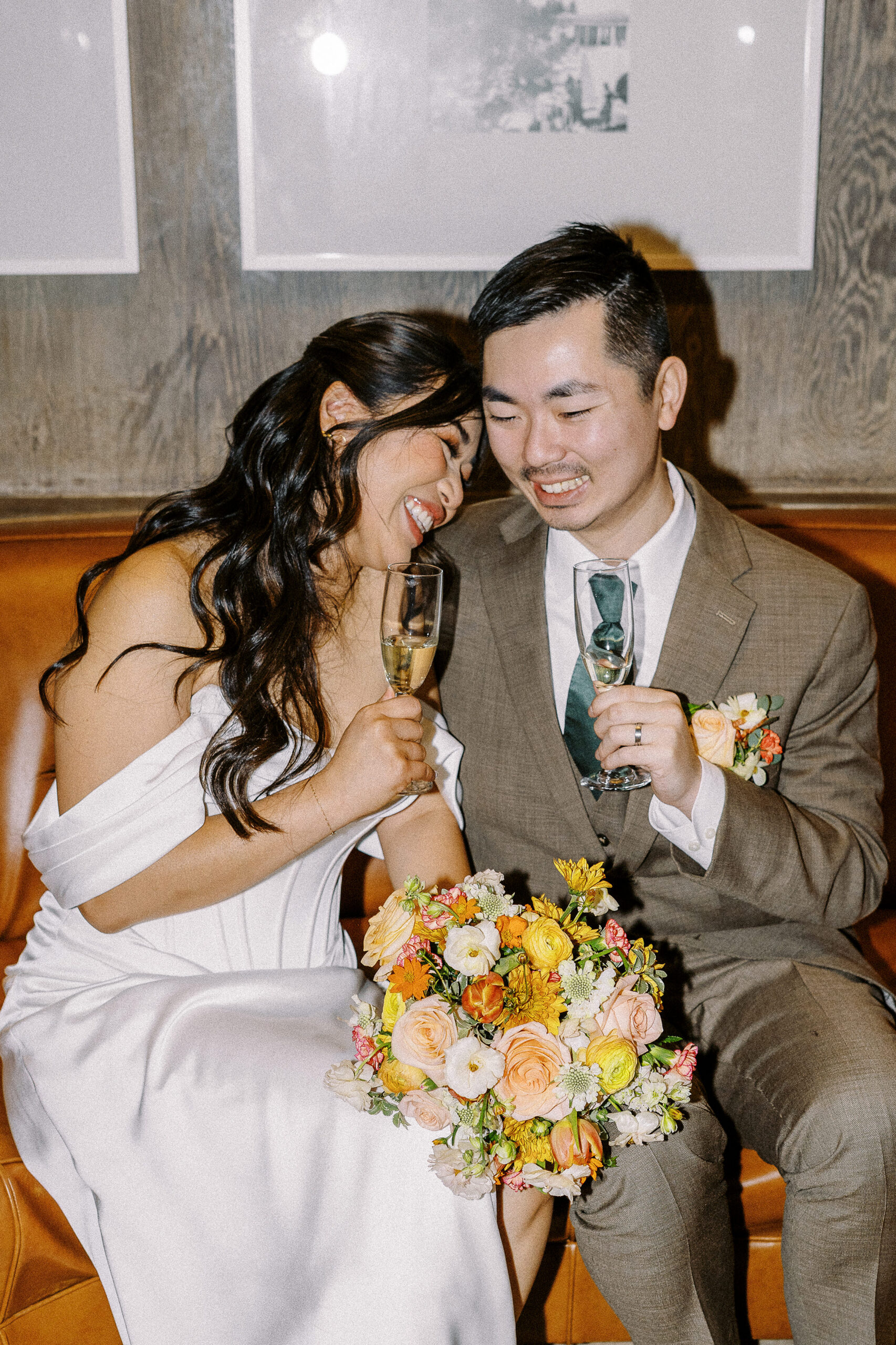 a flash wedding photo of a bride laughing with her groom and laying her head on his shoulder at their Hacienda De Las Flores Wedding
